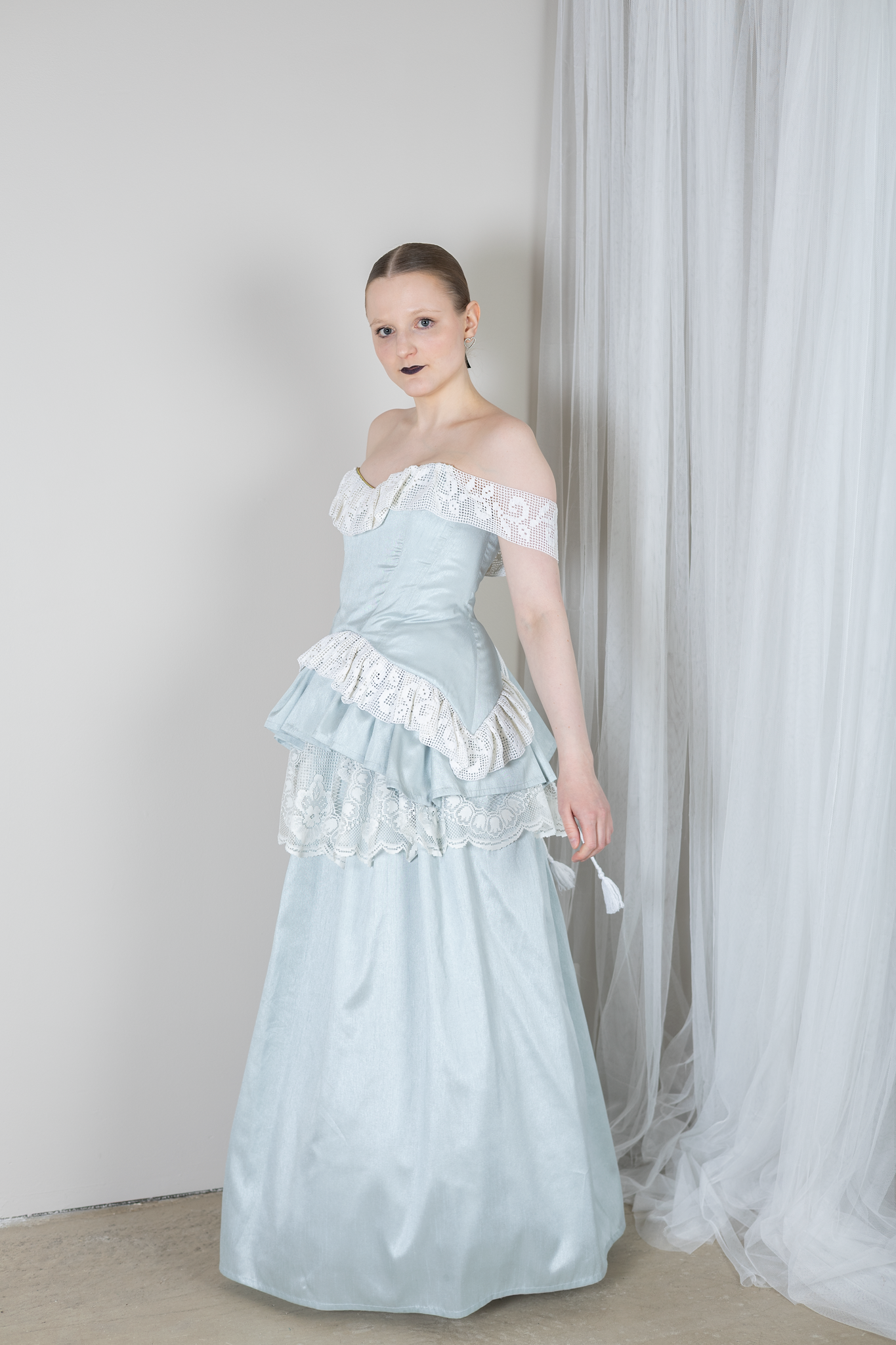 Vaaleansinisistä ja valkoisista verhoista tehty vuokramekko. Mekko on hyvin dramaattinen sekä elegantti, joka muistuttaa prinsessa sekä keskiaikaistyylejä. 